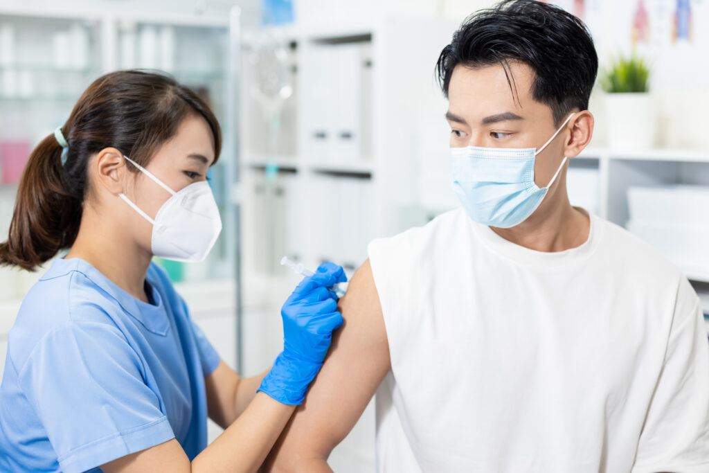 man getting flu shot from pharmacist